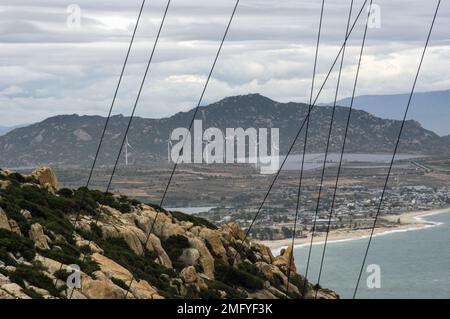 Hilly landscape just outside Phan Rang Vietnam, with cloudy skies on a partially sunny day with the mountains sloping down to the sea Stock Photo