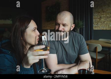 Young couple dining in restaurant and drinking wine. Pair enjoying romantic dinner. Stock Photo