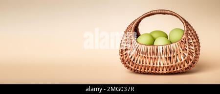 Green natural colored Easter eggs in wicker basket. Ads banner, background with copy space for text, promotion. High quality photo Stock Photo