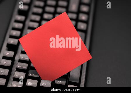 Colored sticker lying on keyboard. Important message written over paper. Stock Photo