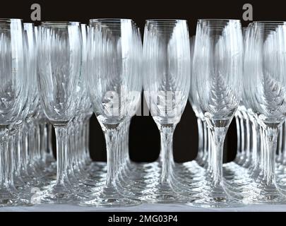 Rows of empty champagne flute glasses on a table at an event waiting to be filled. No people. Stock Photo