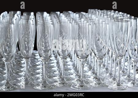 Rows of empty champagne flute glasses on a table at an event waiting to be filled. No people. Stock Photo