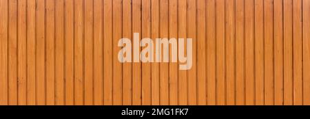 Honey colored varnished panoramic wooden wall made of vertical boards Stock Photo