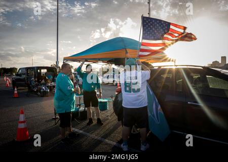 Terry Mohr, from the Brooklyn borough of New York, hoists a flag as he  tailgates with friends before an NFL football game between the Jacksonville  Jaguars and the Miami Dolphins, Thursday, Sept.