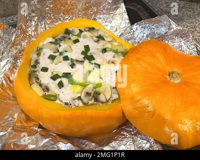 Roast chicken with mushrooms and cheese in baked pumpkin Stock Photo
