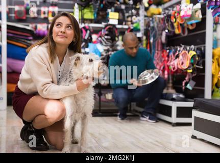 Smiling woman hugging dog in pet shop Stock Photo