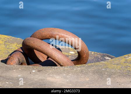 Close up of rusty mooring rings on a quay in a river harbour Stock Photo