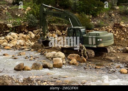 Montecito, California, USA. 13th Jan, 2023. U.S. Army Pfc. Levi Walkup of the California Army National Guard's 649th Engineer Company, 185th Military Police Battalion, 49th Military Police Brigade, traverses a trail of boulder he placed to shorten the route between his excavator and a mission planning area while working to reroute part of the San Ysidro Creek inside the Randall Road Debris Basin, January. 13, 2023, in Montecito, California, as part of the state's storm response. The basin is in the same area where a deadly mudflow hit in 2018. The engineers are supporting the Santa Bar Stock Photo