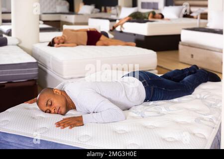 Man sleeping on mattress in furniture showroom Stock Photo