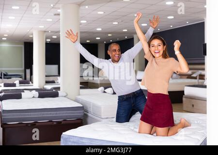 Couple delighted with mattress bought in shop Stock Photo