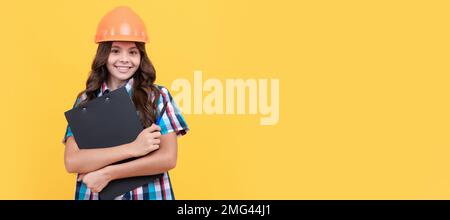 Engineer teenager girl. happy teen girl in construction helmet hold in clipboard, verify data. Child builder in helmet horizontal poster design Stock Photo