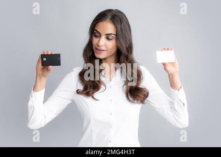 Woman holds template mockup bank credit card with online service isolated on gray background. Happy attractive young girl showing credit. Stock Photo