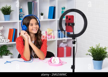 Blogging, videoblog. Teenager child blogger with phone recording video. Influencer teen girl speaking in front of smartphone. Happy girl face Stock Photo