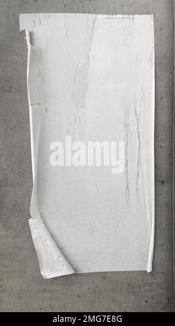 A warn and weathered blank wall poster is peeling off a concrete wall Stock Photo