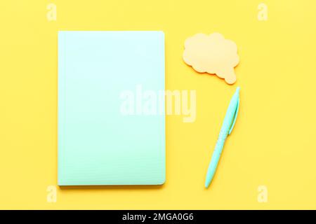Notebook, pen and sticky notes on yellow background Stock Photo