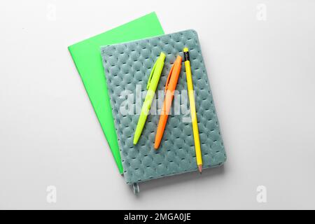 Notebooks, pens and pencil on light background Stock Photo