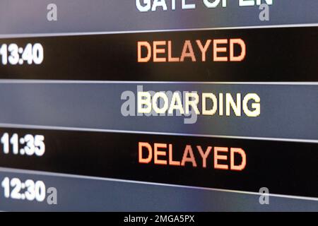 Close-up on airport flight information digital board with focus on the word Delayed Stock Photo