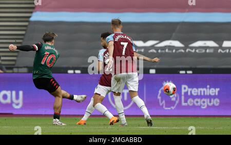 Aston Villa's Jack Grealish, left shoots and scores the opening goal of the game during the English Premier League soccer match between West Ham United and Aston Villa at the London Stadium in London, Sunday, July 26, 2020. (AP Photo/Matt Dunham)