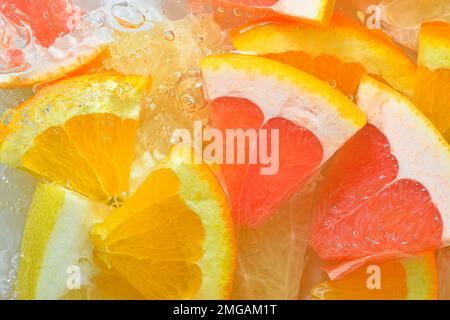 Fresh slices of grapefruit, orange fruit and honey pomelo on white background. Pieces of grapefruit, orange fruit and honey pomelo in sparkling water Stock Photo