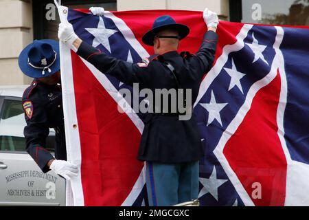 A Mississippi Highway Safety Patrol honor guard carefully folds the