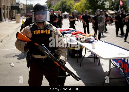 FILE - In this June 20, 2020, file photo a trooper stands outside the BOK Center where President Trump will hold a campaign rally in Tulsa, Okla. In law enforcement, they’re referred to as “non-lethal” tools for crowd control: Rubber bullets. Pepper spray. Batons. Flash-bangs. But the now-familiar scenes of U.S. police officers in riot gear clashing with protesters at Lafayette Park in Washington and elsewhere around the country have police critics charging that the weaponry too often escalates tensions and hurts innocent people. (AP Photo/Charlie Riedel, File)