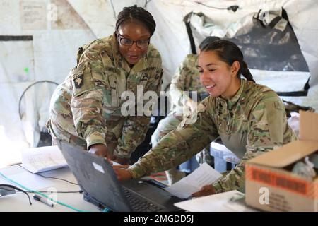 Chief Naushia Smith, and Cpl. Gema Vargas assigned to the Supply Support Activity (SSA) team of the 404th Aviation Support Battalion, 4th Combat Aviation Brigade, 4th Infantry Division assists a customer with an order during field training at Fort Carson, Colorado, Aug. 22, 2022. The field training was to enhance the unit's reaction to combat the enemy for all levels of support. Stock Photo