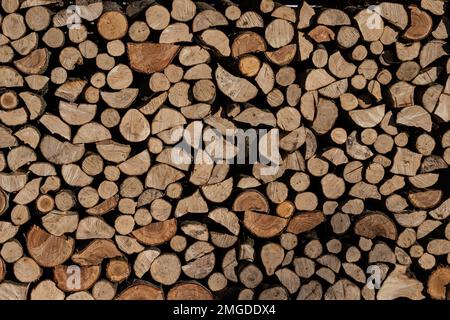 Pile of stacked triangle firewood prepared for fireplace and boiler. Stock Photo