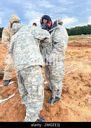 U.S. Army Soldiers assigned to the 83rd Chemical Battalion and the 'Mustang Squadron,' 6th Squadron, 8th Cavalry Regiment, 2nd Armored Brigade Combat Team, 3rd Infantry Division, don their decontamination suits during a joint decontamination exercise on Fort Stewart, Georgia, Aug. 24, 2022. Chemical, biological, radiological and nuclear skills, such as decontamination, exist to enable movement and maneuver to conduct large-scale ground combat operations in a CBRN environment. Stock Photo