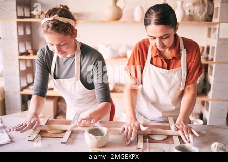 Pottery, design and small business people in workshop teamwork, collaboration and startup production. Clay, manufacturing and creative woman, artist Stock Photo