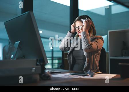 Shes reached her breaking point. a young businesswoman looking frustrated while working late in an office. Stock Photo