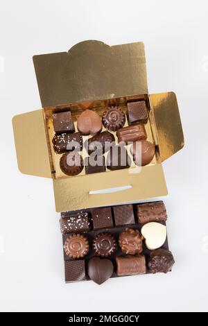 golden box assortment many small square fine chocolate candies milk dark in gift square open gold carton Stock Photo