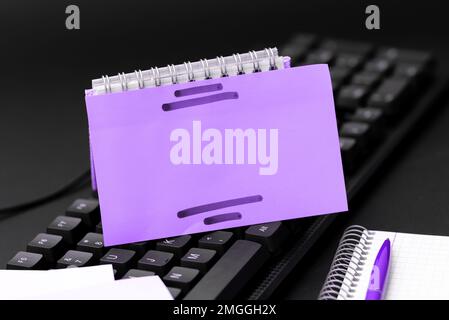 Colored sticker lying on black keyboard. Important information written over paper. Image with school supplies. Multiple Assorted Collection Office Stock Photo