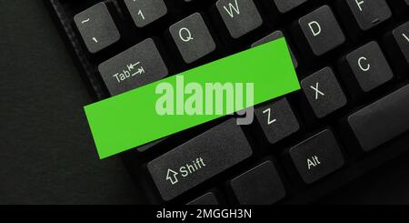Sticker lying on black keyboard. Important message written over paper. Stock Photo