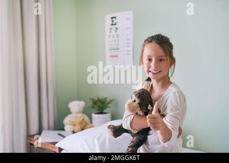 Monkey offered to be examined before me. a little girl holding her stuffed monkey while visiting the doctor. Stock Photo