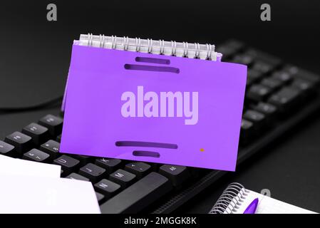 Colored sticker lying on black keyboard. Important information written over paper. Image with school supplies. Multiple Assorted Collection Office Stock Photo