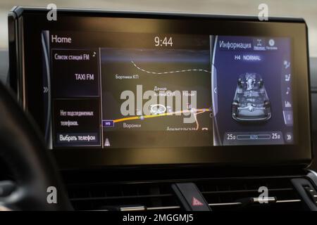 Modern car media display in the interior of the car. Translation 'Stations list. No connected phone. Chose phone. Information. Different names of vill Stock Photo
