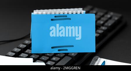 Colored sticker lying on black keyboard. Important information written over paper. Image with school supplies. Multiple Assorted Collection Office Stock Photo