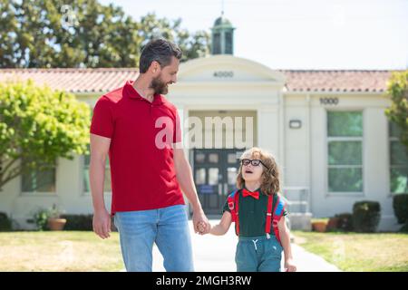 Father and son run with father after come back from school. Kids education and outdoor concept. Stock Photo