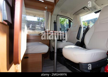 Camper Cabin Interior traveling in CamperVan with table and white seat in recreational vehicle van for vanlife holidays trip Stock Photo