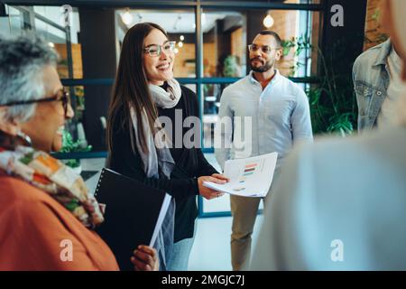 Cheerful businesspeople holding a staff meeting in a modern office. Group of multicultural entrepreneurs running a successful startup in an inclusive Stock Photo