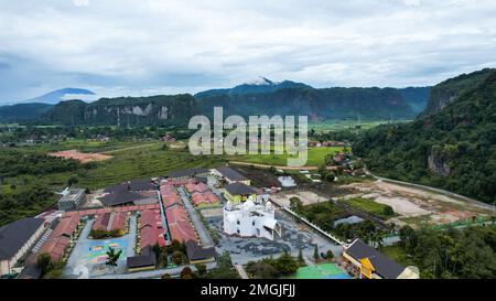 Aerial view of white mosque in a beautiful landscape view of Harau Valley with mountains valley and grass view, Beautiful Minangkabau. West Sumatera, Stock Photo