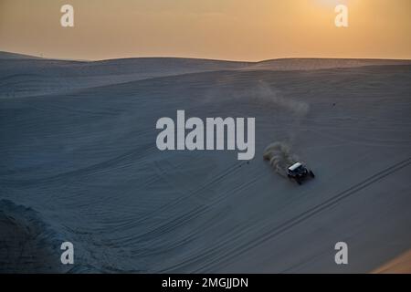 A 4x4 buggy racing over the dunes near Doha, where tourists and Qataris thrill seekers alike go for entertainment. Stock Photo