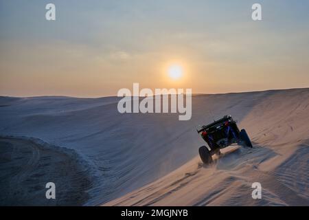 A 4x4 buggy racing over the dunes near Doha, where tourists and Qataris thrill seekers alike go for entertainment. Stock Photo