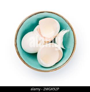 Blue bowl with eggshell isolated. Top view of eggshell in bowl on white background. Stock Photo