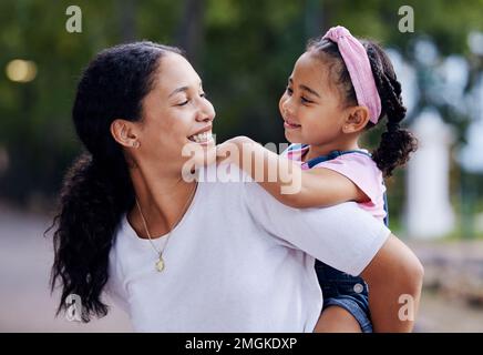 Woman, girl child and smile for piggyback ride in urban park, street and outdoor for love, bonding or care. Excited family, mother and daughter for Stock Photo