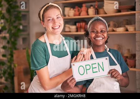 Small business, pottery and women team with open sign for creative workshop, art studio and startup. Smile, teamwork and entrepreneurs ready for Stock Photo