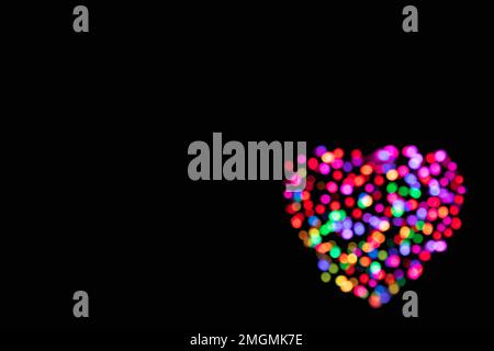 Abstract background of multicoloured blurred lights in the shape of a heart with copy space Stock Photo