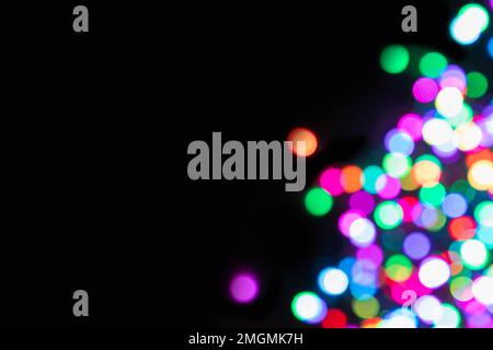 Black background with defocused coloured lights on the right side with with copy space (bokeh effect) Stock Photo