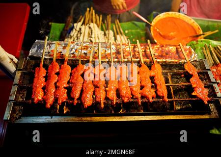 Street food of Thai meatball fried with spicy sauce at barbecue without hand at outdoor night market at the Chinese New year in Bangkok Chinatown in T Stock Photo