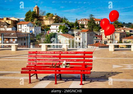 A bench painted red for the International Day for the Elimination of Violence against Women (November 25) in Piazza dei Vestini, Pianella, Italy Stock Photo